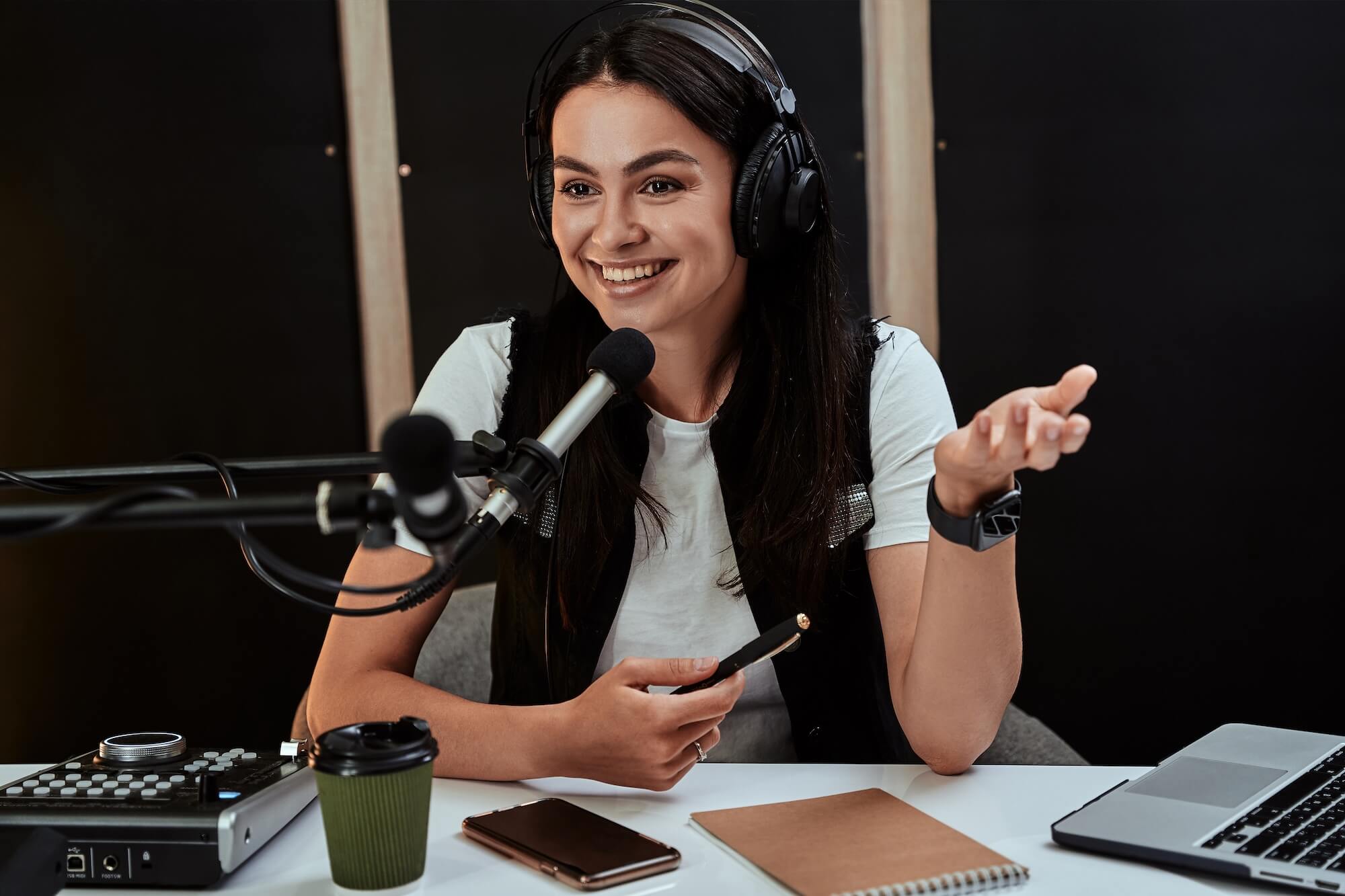 A content creator recording with a microphone while using a laptop.